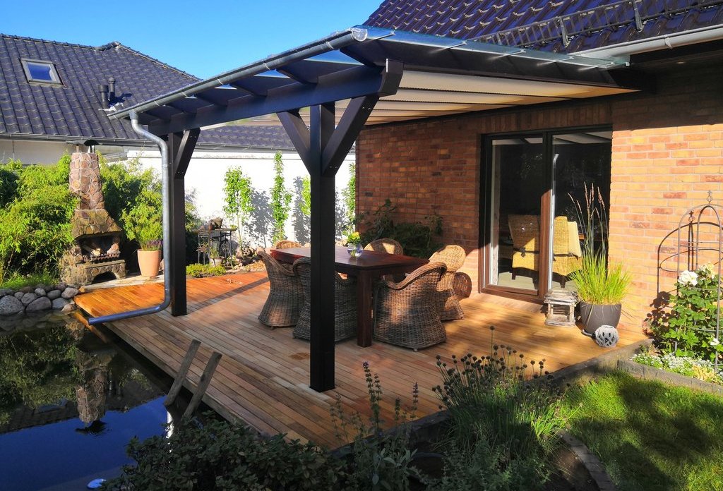 Eine Terrassenüberdachung aus Holz über einer Holzterrasse