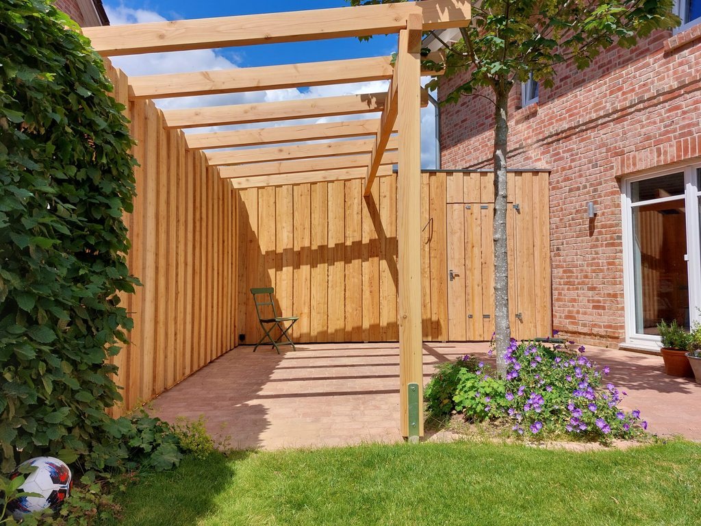 umgesetzt von Holzhof Friedrichsruh: Sichtschutzwand mit Boden-Deckel-Verschalung & Pergola – stilvolle Abtrennung Sichtschutzwand mit Boden-Deckel-Verschalung & Pergola – stilvolle Abtrennung
