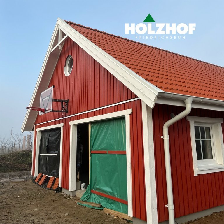 umgesetzt von Holzhof Friedrichsruh: Schwedenhaus-Garage mit zwei Sektionaltoren – skandinavisches Design Schwedenhaus-Garage mit zwei Sektionaltoren – skandinavisches Design